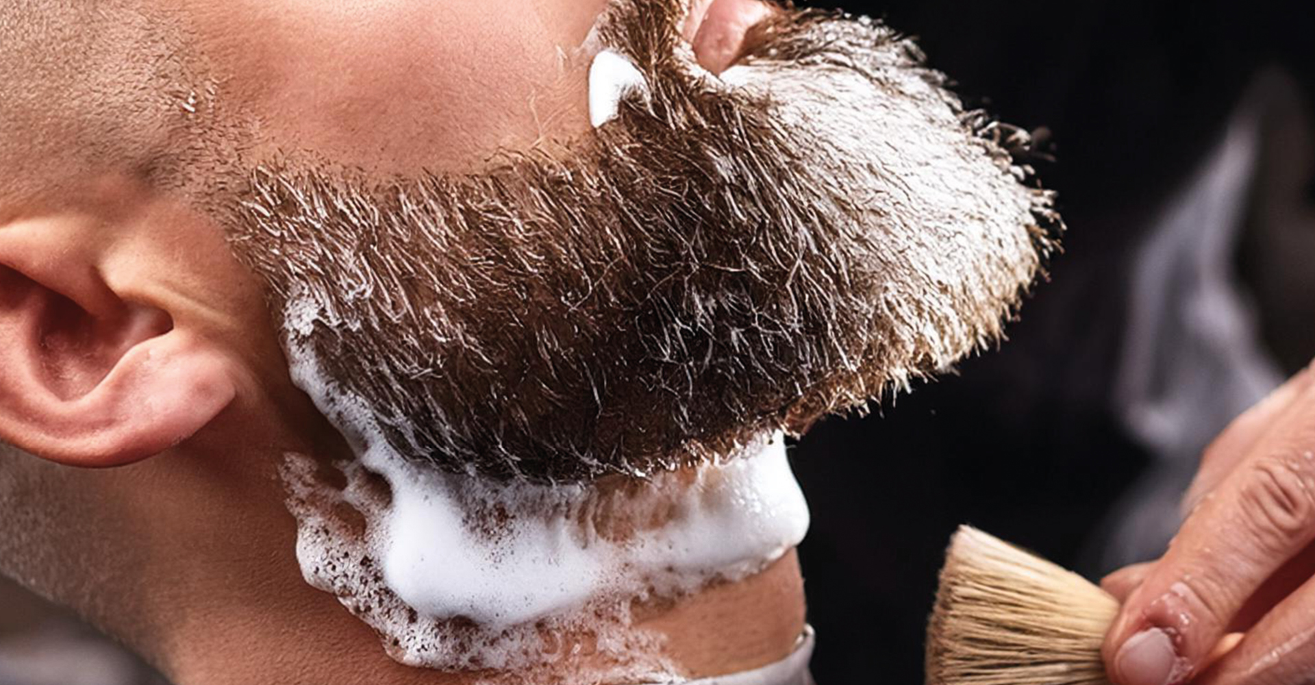 volto di un uomo con barba lunga e coperta di sapone